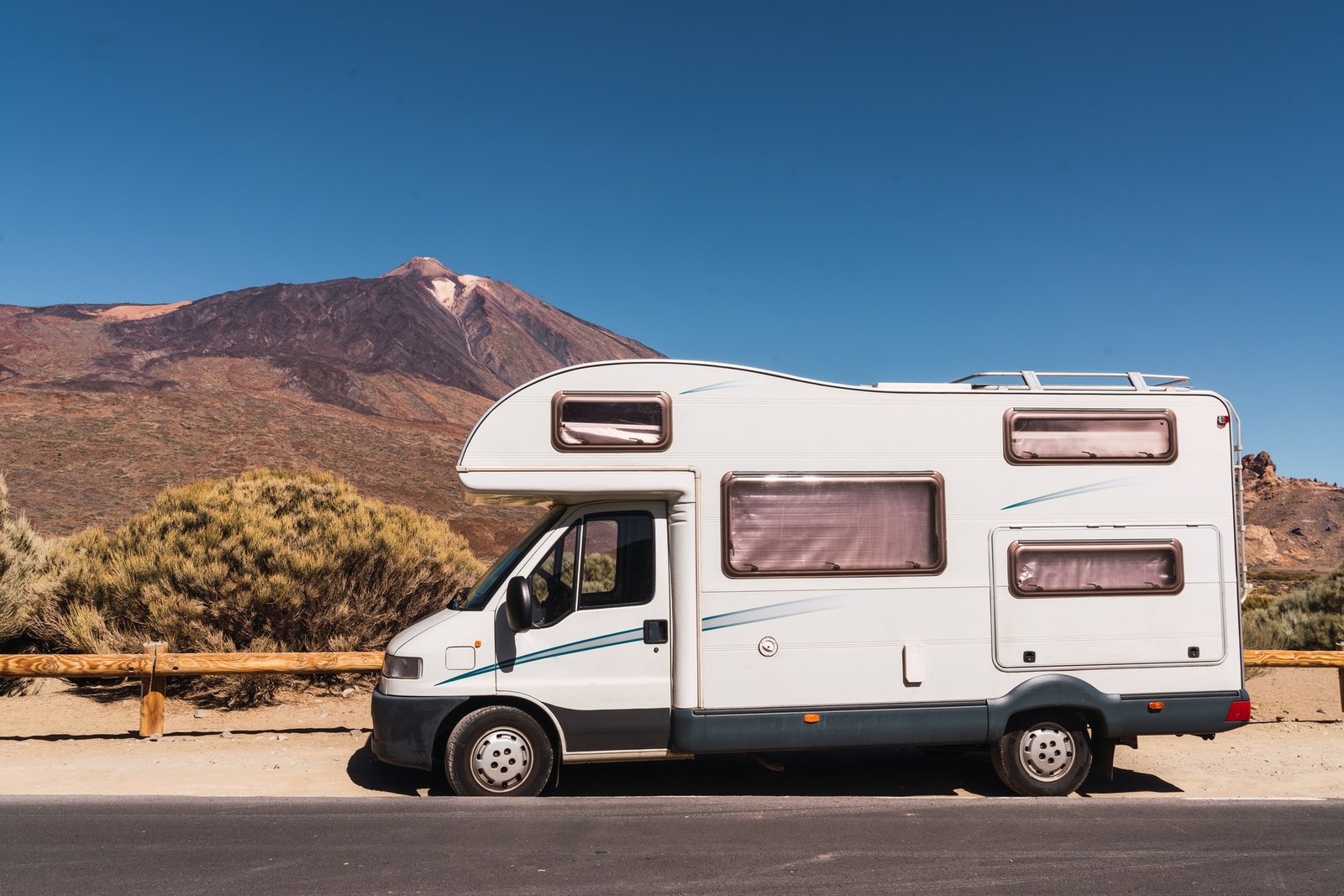 camper van on road near hill and blue sky.jpg